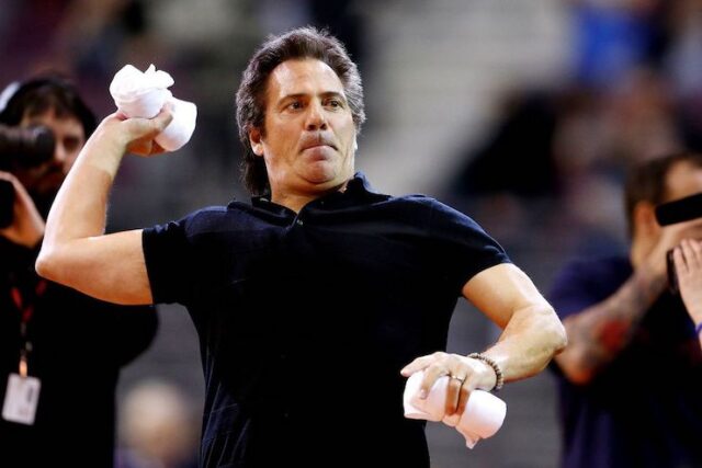 Detroit pistons owner and billionaire Tom Gores pictured at a Detroit Pistons game throwing shirts into a crowd of fans.