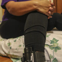 An image of a woman wearing an ankle monitor, one of many surveillance conditions bail bondsmen impose on their “customers.”