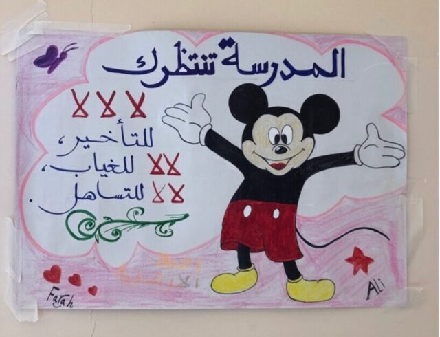 A student’s drawing of Mickey Mouse with words in Arabic that read “school is waiting for you” and lists the school’s policies.
