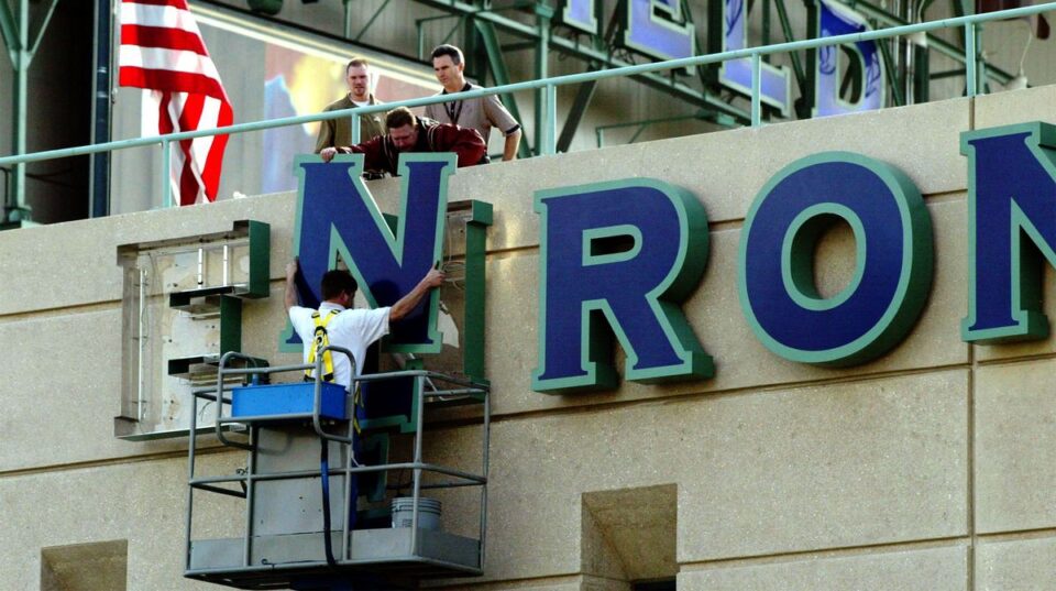 Enron lettering being removed from its headquarters.