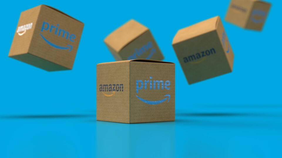 Amazon Prime delivery boxes are shown against a blue background 