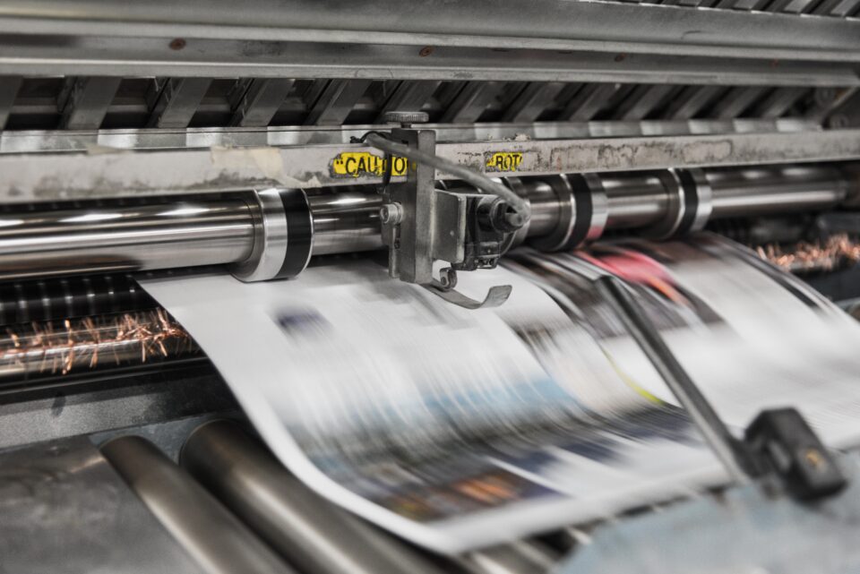 Blurred photo of a newspaper being printed. 