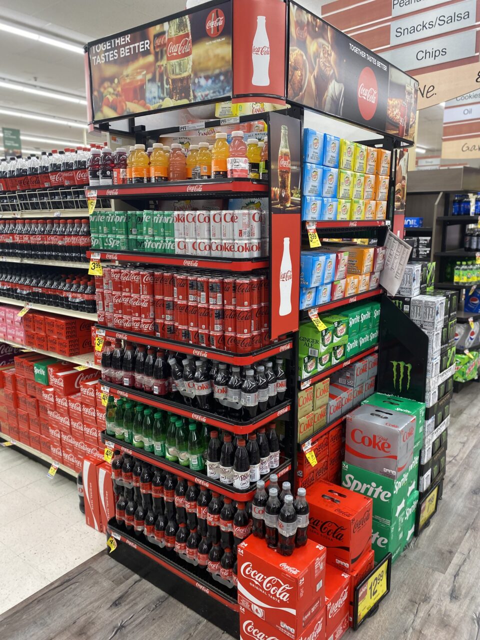 A supermarket display of various soft drinks including Sprite, Coca Cola, and Ginger Ale 