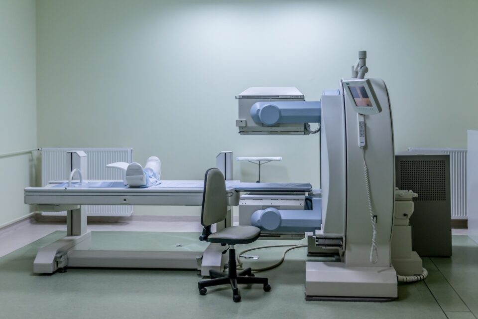An unoccupied MRI machine in a white examination room