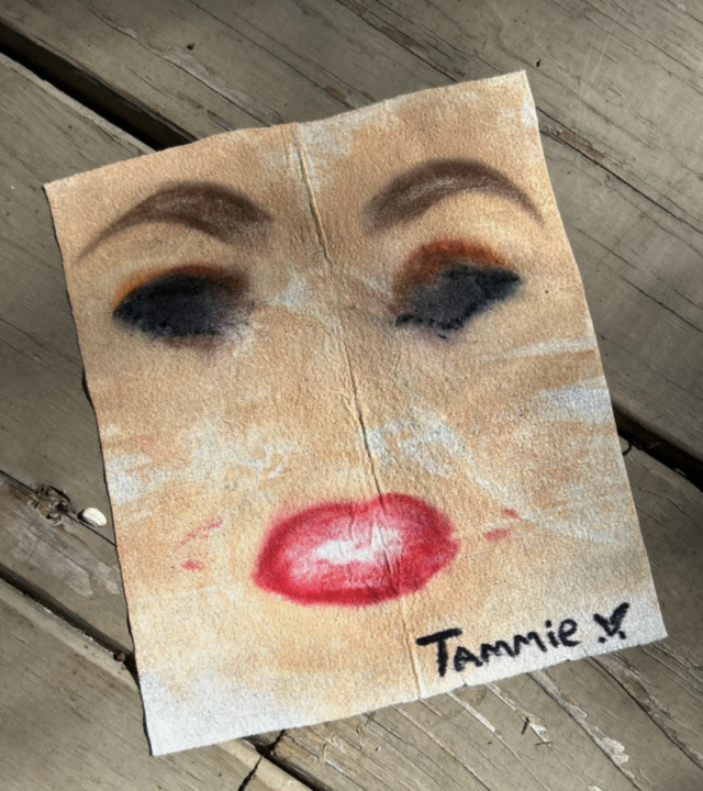 A smudged face of makeup appears on a makeup wipe with the name “Tammie” written in black ink in the lower right corner.