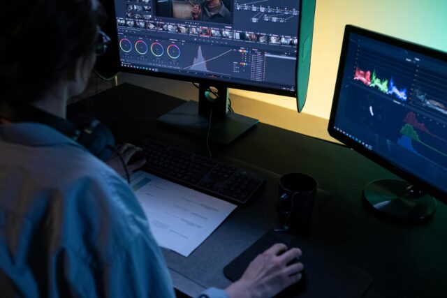 Photo of a woman using editing equipment on a computer.