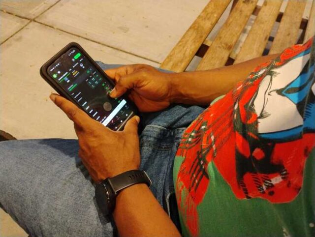 A pair of hands holding a phone with a sports gambling app on the screen.