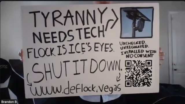 A man holds up a handmade protest sign written in black marker on white poster board. The sign reads, in block letters: "TYRANNY NEEDS TECH," with an arrow pointing to a small inset image of a Flock Safety surveillance camera mounted on a solar-powered pole. Below: "FLOCK IS ICE'S EYES. SHUT IT DOWN.” A handwritten note in the upper right corner reads, "UNCHECKED. UNREGULATED. INSTALLED WITH NO CONSENT." A QR code is printed in the lower right corner of the sign.