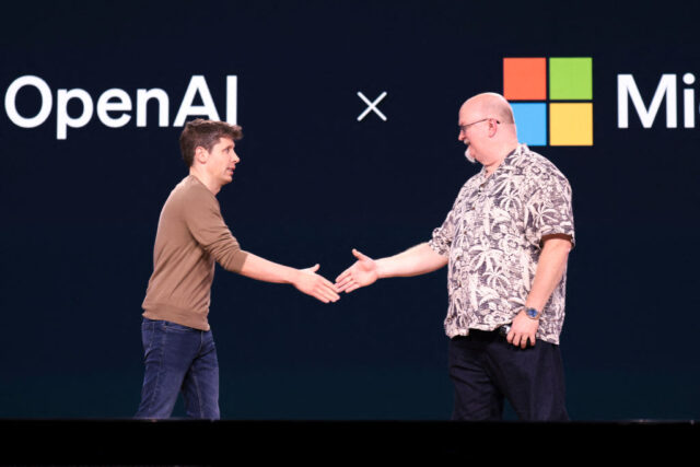 Sam Altman and Kevin Scott shaking hands on stage at a Microsoft conference in Seattle.